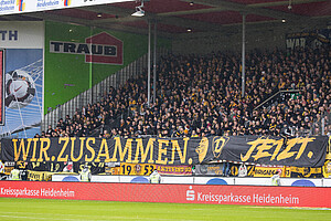 "Wir. Zusammen. Jetzt." signalisieren die rund 1.500 Dynamo-Fans, die den Weg nach Heidenheim angetreten haben. 