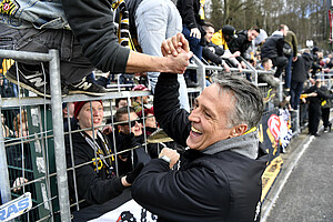 Nach dem Spiel klatscht Dynamo-Trainer Neuhaus mit den Fans ab.
